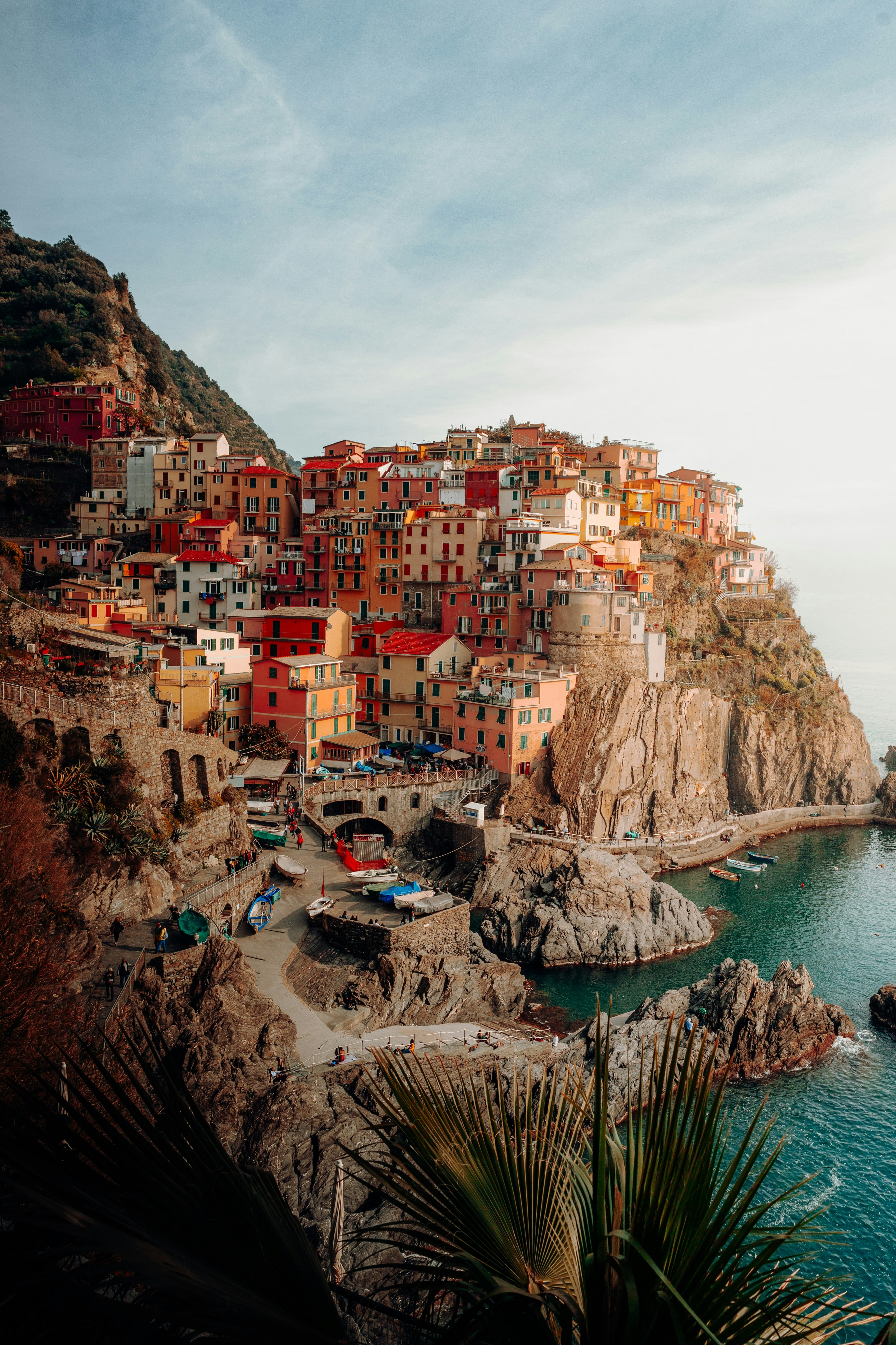 The pastel cliffside village of Manarola in Cinque Terre, perched above its harbor and the Ligurian Sea at golden hour